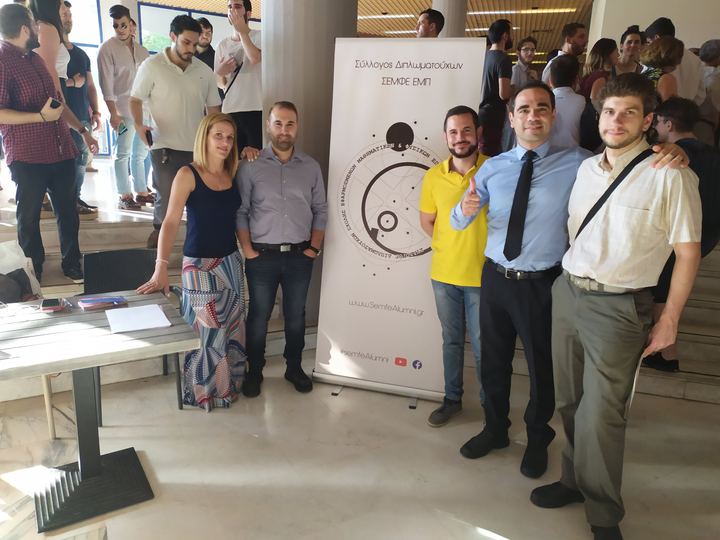 Members of the Association next to the Association's banner at an event